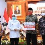 Gubernur Jatim Khofifah Indar Parawansa dan Menteri Koperasi dan UKM RI Teten Masduki secara simbolis menyerahkan Bantuan Presiden Produktif Usaha Mikro (BANPRES – PUM).di Gedung Negara Grahadi Surabaya pada Rabu (30/9) siang. foto: ist/ bangsaonline.com