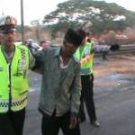 TERLUKA - Polisi tengah membantu seorang korban yang terluka sesaat setelah Bus Harapan Jaya, terguling di Jalan Raya Bungurasih, depan kantor Mahkamah Militer (Mahmil) Waru, Sidoarjo, Senin (13/10/2014). foto istimewa