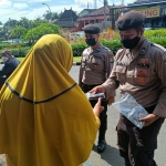 Petugas Satsabhara Polres Batu bagi-bagi masker saat operasi yustisi.