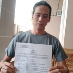 Korban saat menunjukkan surat laporan kepada awak media.