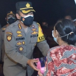 Kapolresta Sidoarjo Kombes Pol. Kusumo Wahyu Bintoro beserta jajaran saat memberikan bantuan sosial kepada para penggali makam dan warga nelayan berupa paket sembako, Selasa (27/7/2021) malam. foto: ist.