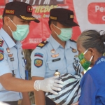 Kepala Rutan Trenggalek Sjamsudi Wahjunto (kiri) saat membagikan paket sembako pada warga sekitar Rutan Trenggalek. foto: HERMAN/ BANGSAONLINE