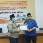 Koordinator Forkom Jurnalis Nahdliyin, Muhamad Didi Rosadi yang juga wartawan HARIAN BANGSA dan BANGSAONLINE menyerahkan cinderamata kepada Subairi, Komisioner KPU Surabaya Divisi Sosialisasi, Pendidikan Pemilih, Partisipasi Masyarakat, dan SDM Graha Pemuda, Komplek Museum NU, Surabaya. foto: ist.