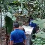 Petugas dari BKSDA Kediri saat membawa alat jebakan ke arah sungai munculnya anak buaya. Foto: Ist