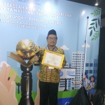 Kepala MAN 1 Tuban, Ahmad Hudan saat menerima penghargaan di acara Festival Adiwiyata Nawasena 2024