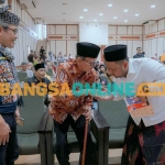 Bupati Gresik, Fandi Akhmad Yani, berjabat tangan dengan KH D. Zawawi Imron saat launching buku piknik literasi. Foto: SYUHUD/BANGSAONLINE