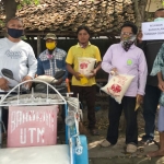 Relawan Bangkalan Tanggap (RBT) Covid-19 saat memberikan bantuan berupa beras dan minyak goreng kepada tukang becak.