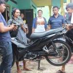 Keempat pemuda menunjukkan aksinya mengangkat motor dengan dua jari usai membasuh tangannya menggunakan air rendaman batu Marantale. (foto: khumaidi/BANGSAONLINE)