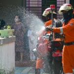 Petugas melakukan penyemprotan disinfektan.