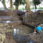 Suasana kolam sedang yang sedang dibersihkan oleh warga.