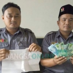 Petugas Bawaslu menunjukkan barang bukti uang beserta lembaran daftar penerima. foto: NOVIAN/ BANGSAONLINE