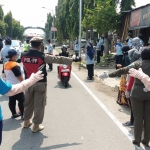 Kepala Kantor Imigrasi Kelas III Ponorogo Hendriya Widjaya saat membagikan masker ke masyarakat pengguna jalan.