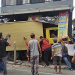 Warga saat mengevakuasi mobil boks yang nyungsep ke toko di Kota Blitar.