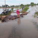 Salah satu warga kesulitan saat hendak melewati jembatan darurat.