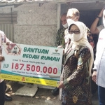 Ketua Baznas Jatim KH Muhammad Roziqi menyerahkan bantuan program bedah rumah secara simbolis kepada Bupati Jombang Hj Mundjidah Wahab, dengan total Rp 187.500.000, disaksikan Ketua Baznas Jombang, H. Didin Ahmad Sholahudin. foto: YUDI A/BANGSAONLINE