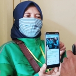 Hariyanti (49), salah satu pengemudi ojek online saat menunjukkan bukti komentar di slah satu akun instagram yang diduga ada unsur penghinaan. foto: MUJI HARJITA/BANGSAONLINE