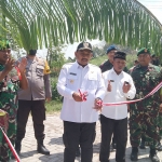 Bupati Ngawi Ony Anwar Harsono menggunting pita sebagai tanda peresmian jalan desa hasil program TMMD di Desa Gunungsari. Foto: ZAINAL ABIDIN/  BANGSAONLINE