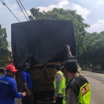 Petugas saat melakukan penyekatan lalu lintas ternak di Keplaksari, Peterongan, Jombang.