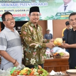 SIMBOLIS: Bupati Muhdlor memberikan potongan tumpeng ke Kades Kalimati Kisno Mulyo saat meresmikan Kantor Pelayanan Desa Kalimati Tarik, Sabtu (3/6/2023). Foto: Ist.