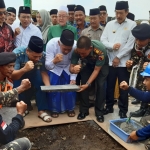 ?SIMBOLIS: KH Marzuki Mustamar (tengah) saat peletakan batu pertama Masjid KH Muhammad Hasyim Asyari, Rabu (11/3). foto: MUSTAIN/BANGSAONLINE