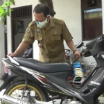 Kades Sukorejo Fathur Rokhman dengan motor dinasnya saat hendak berangkat dari rumah dinasnya ke kantor di Balai Desa Sukorejo. foto: SYUHUD/ BANGSAONLINE