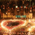 Kapolres Gresik, AKBP Mochamad Nur Azis, bersama Ultrasmania saat menggelar doa bersama untuk korban tragedi di Stadion Kanjuruhan Malang. Foto: SYUHUD/BANGSAONLINE