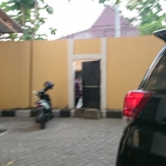 Kepala Dinas Pendidikan (Disdik) Bangkalan Bambang Budi Mustika keluar dari pintu tikus sebelah kiri gedung Kejari untuk mengelabui wartawan yang menunggu. foto: FAUZI/ BANGSAONLINE