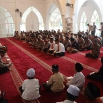 Wakapolres Pasuruan Kompol Hari Aziz bersama kabag SDM saat membagikan santunan untuk anak yatim.