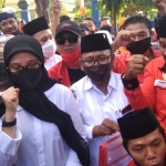 Calon Bupati Ipuk Fiestiandani mengepalkan tangan penuh semangat didampingi calon Wakil Bupati Sugirah dan para pimpinan partai pengusung dan pendukung saat menuju KPU Banyuwangi untuk mendaftar, Ahad (6/9/2020). foto: teguh/ bangsaonline.com