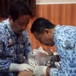 Petugas medis sedang menyunat salah satu peserta khitan massal.