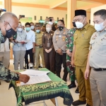 Bupati Gus Yani didampingi Kepala ATR/BPN Asep Heri dan pejabat Forkopimda saat menyaksikan pembayaran ganti untung pembebasan lahan normalisasi Kali Lamong. foto: SYUHUD/BANGSAONLINE