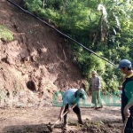 Warga Desa Balerejo membersihkan jalan dari material longsor. foto: AKINA/ BANGSAONLINE