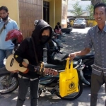 Kader Golkar Gresik saat membagikan bantuan sembako dan multivitamin kepada warga kurang beruntung yang terdampak PPKM Darurat Covid-19. (foto: SYUHUD/ BANGSAONLINE)