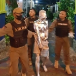 Petugas Satpol PP Gresik saat mengamankan manusia silver. Foto: Ist