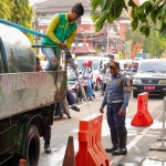 Petugas saat mengisi air untuk pembatas jalan agar tidak digunakan untuk parkir liar. Foto: Ist