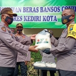 Kapolsek Mojoroto AKP Sartana (kiri) saat menerima bantuan beras secara simbolis dari Kapolres Kediri Kota, AKBP Miko Indrayana. foto: muji harjita/ bangsaonline.com