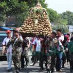 Tumpeng ketupat cokelat saat diarak oleh ratusan warga Kampung Coklat. foto: AKINA/ BANGSAONLINE