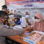 Petugas dari Polres Madiun saat memberikan bantuan tunai kepada salah seorang pedagang kaki lima