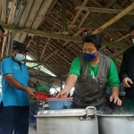 Koordinator GSLK, Zainal Hamami atau lebih dikenal dengan sebutan Mbah Mamik (kiri) bersama timnya saat meramu wedang nglaban. (foto: ist.)