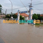 Luapan air sungai konang yang menggenang di jalan Nasional Sampang-bangkalan. Foto : MUTAMMIM/BANGSAONLINE