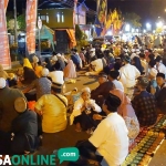 Jemaah yang tidak kebagian tempat di Haul Gus Dur ke-9 terpaksa duduk di jalan raya Jombang-Kediri. foto: RONY S/ BANGSAONLINE