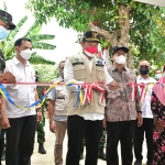 Bupati Yuhronur potong pita pembukaan jalan baru. (foto: ist)