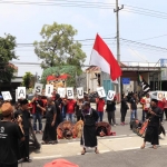 Massa saat menggelar tagar #Kami Masih Butuh Polisi di depan Mapolres Jombang.