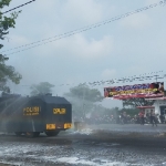 Polisi menurunkan satu unit water cannon untuk menyemprotkan cairan disinfektan di pasar hewan yang sedang ditutup.