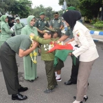 Danrem 081/DSJ saat dikalungi bunga oleh dua tentara cilik.