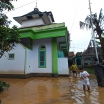 Luapan banjir tampak sudah mulai memasuki halaman rumah.