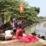 RUSAK LINGKUNGAN: Aktivitas mencuci kulit bawang merah yang dilakukan warga Desa Jati Kalang Kecamatan Prambon sehingga ikan menjadi teler, kemarin. foto: khumaidi/BANGSAONLINE