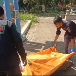 Bhabinkamtibmas Polsek Keraton dan warga saat mengevakuasi jenazah menuju ambulans. Foto: M. ANDY FACHRUDIN/ BANGSAONLINE