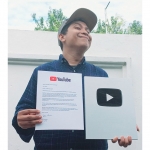 Tamam Mubarok, Pemilik Channel Mamat On Duty, memamerkan silver play button dari YouTube.