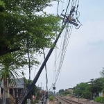 Tiang kabel sinyal yang miring ke jalur kereta api. Foto: Ist.